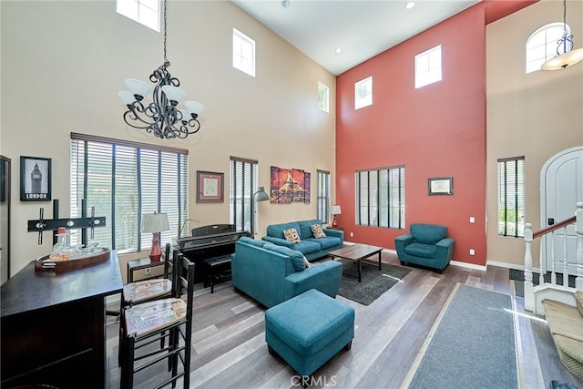 living room with hardwood / wood-style flooring, plenty of natural light, a high ceiling, and a chandelier