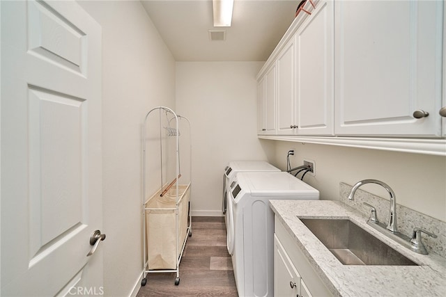 washroom with cabinets, sink, dark wood-type flooring, and washing machine and dryer