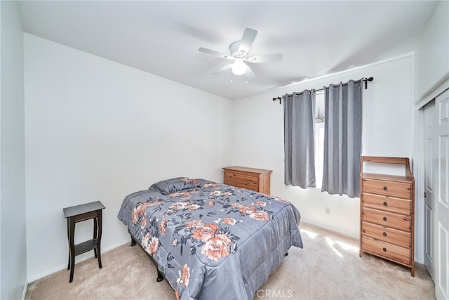 bedroom featuring ceiling fan, a closet, and light carpet