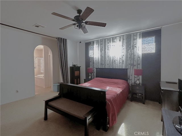 carpeted bedroom featuring ensuite bath and ceiling fan