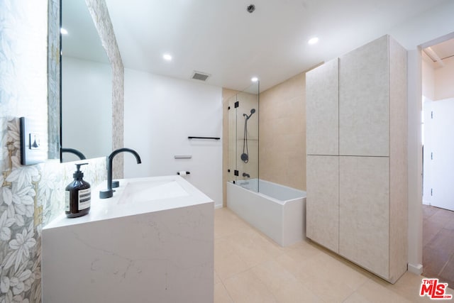 bathroom featuring sink, tiled shower / bath combo, and tile patterned floors