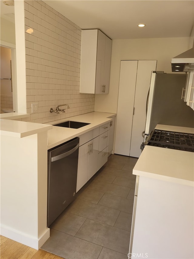 kitchen featuring white cabinets, sink, extractor fan, dishwasher, and decorative backsplash