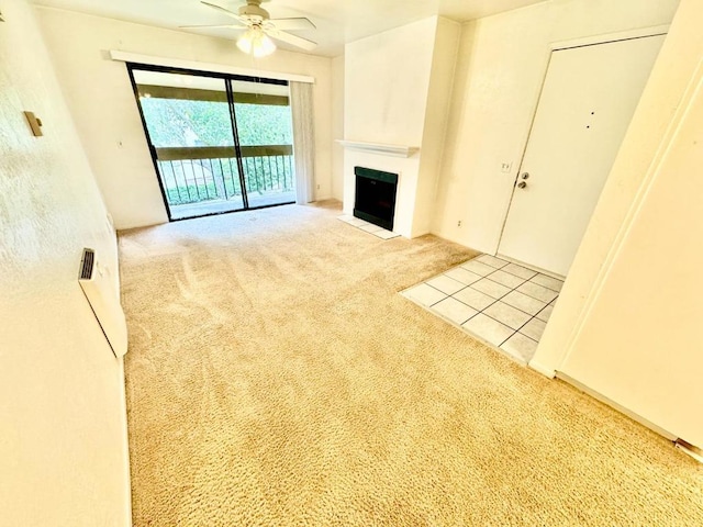 unfurnished living room with light colored carpet and ceiling fan