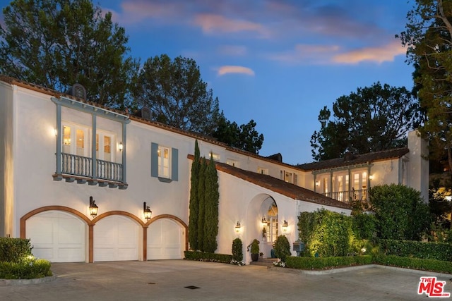 mediterranean / spanish-style home with a balcony and a garage