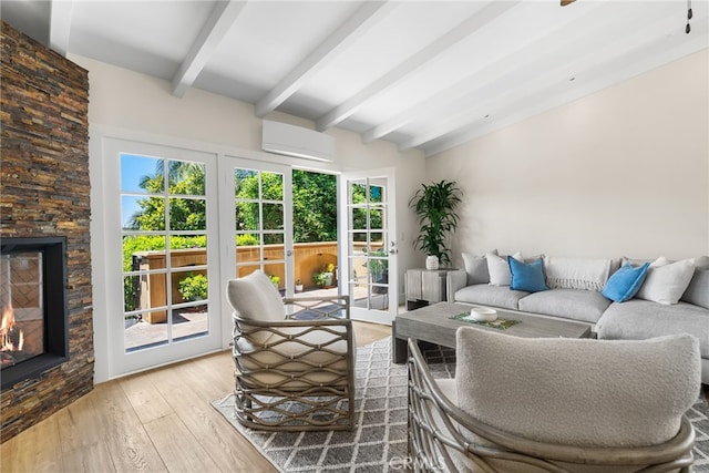 sunroom featuring beam ceiling, a stone fireplace, and an AC wall unit