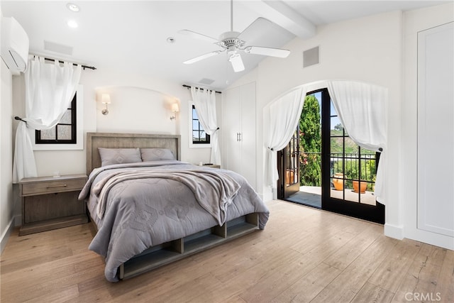 bedroom with access to exterior, ceiling fan, vaulted ceiling with beams, an AC wall unit, and light hardwood / wood-style floors