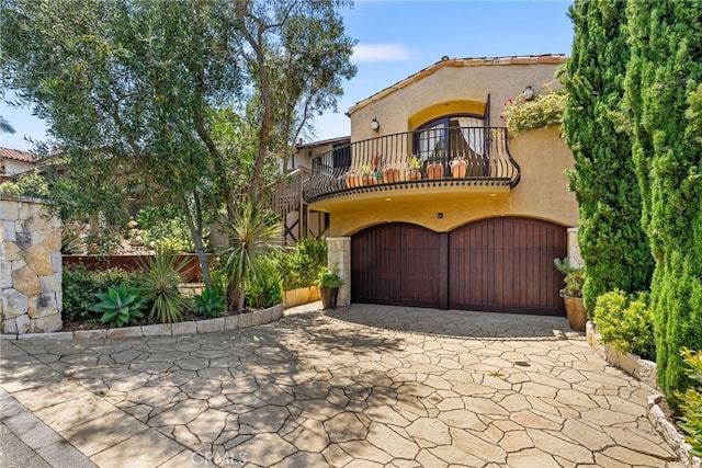 mediterranean / spanish house featuring a balcony and a garage