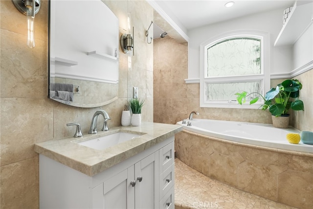 bathroom with tile patterned flooring, vanity, tile walls, and tiled tub