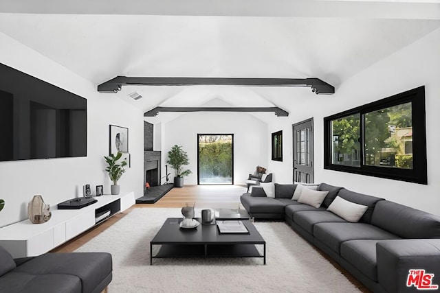 living room featuring vaulted ceiling with beams, plenty of natural light, and hardwood / wood-style flooring