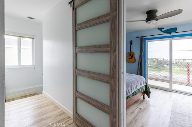 unfurnished bedroom featuring access to exterior, ceiling fan, and light hardwood / wood-style flooring