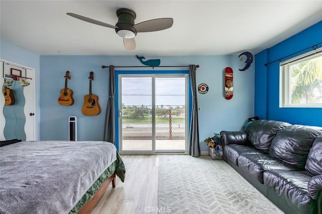 bedroom with access to outside, ceiling fan, and wood-type flooring