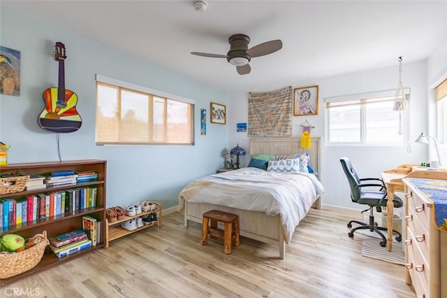 bedroom with ceiling fan, light wood-type flooring, and multiple windows