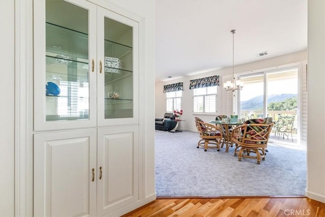 dining room with light hardwood / wood-style floors, plenty of natural light, and a notable chandelier