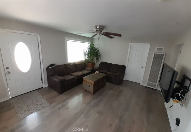 living room featuring ceiling fan and dark wood-type flooring