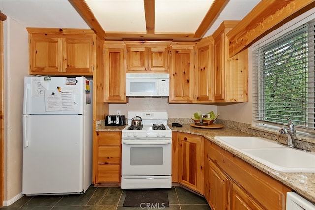 kitchen featuring dark tile patterned flooring, light stone countertops, sink, and white appliances