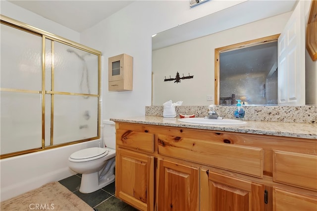 full bathroom featuring vanity, combined bath / shower with glass door, toilet, and tile patterned floors