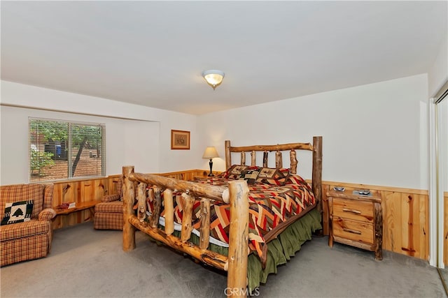 bedroom with carpet and wood walls