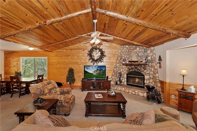 carpeted living room with wood ceiling, ceiling fan, vaulted ceiling with beams, a fireplace, and wooden walls