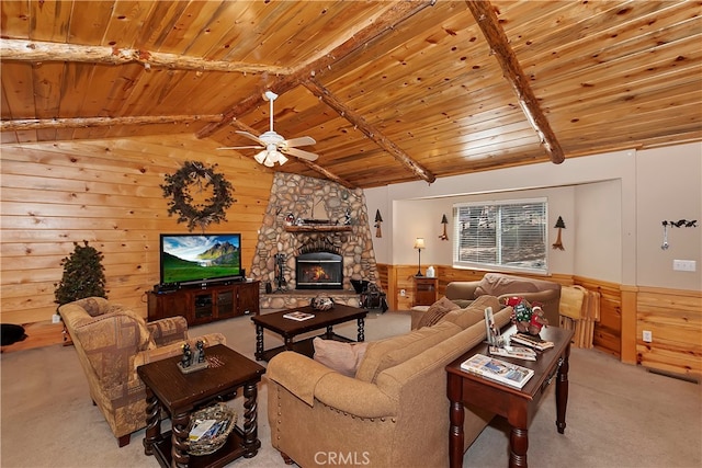 carpeted living room with wooden walls, wooden ceiling, lofted ceiling with beams, a fireplace, and ceiling fan