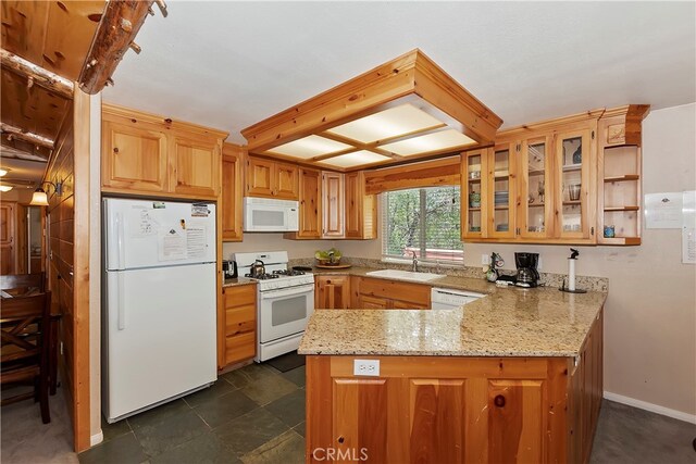 kitchen featuring kitchen peninsula, sink, light stone counters, and white appliances