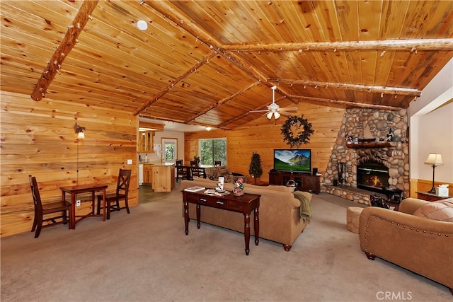 living room featuring wood walls, a fireplace, wood ceiling, light carpet, and ceiling fan