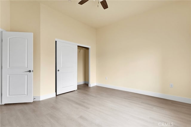 unfurnished bedroom featuring ceiling fan, light wood-type flooring, and a closet