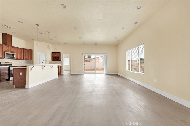 unfurnished living room featuring light hardwood / wood-style floors and a textured ceiling