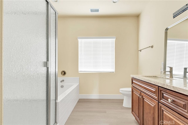 full bathroom with plus walk in shower, hardwood / wood-style flooring, vanity, and toilet