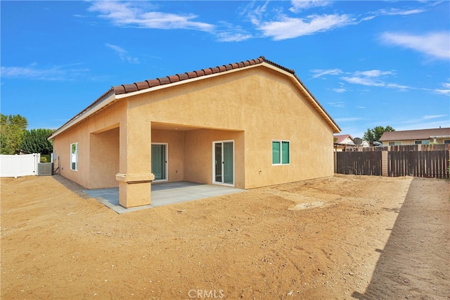 rear view of property with central AC unit and a patio