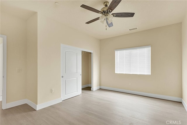 unfurnished bedroom featuring a textured ceiling, light hardwood / wood-style floors, ceiling fan, and a closet