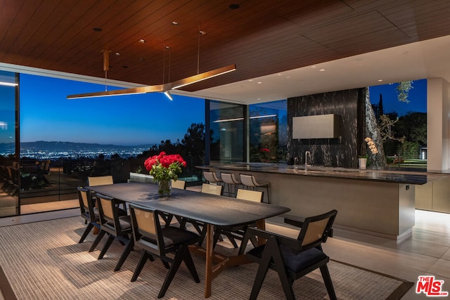 patio terrace at dusk featuring exterior bar and a mountain view