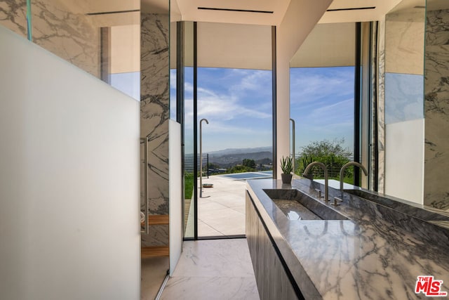 bathroom with a wall of windows, sink, and a mountain view