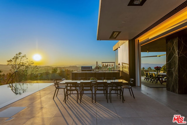 patio terrace at dusk featuring a water view