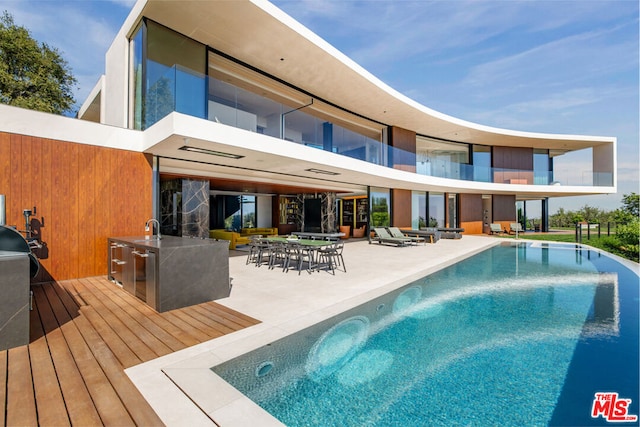 view of swimming pool with a patio, a deck, and sink