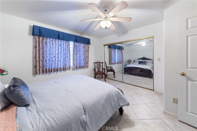 bedroom featuring ceiling fan, a closet, and light tile patterned floors