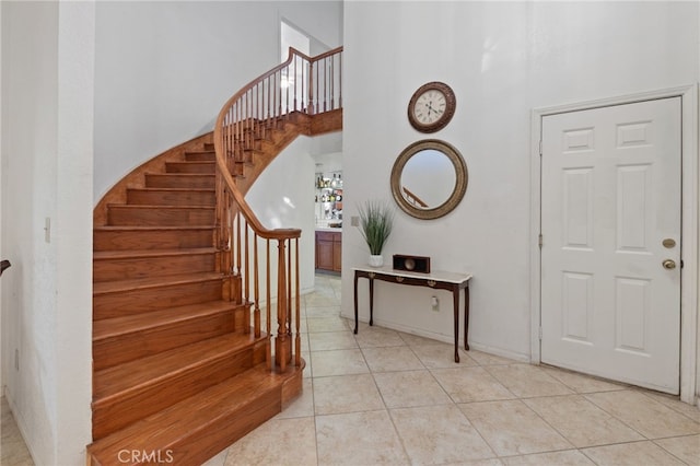 tiled entrance foyer featuring a towering ceiling