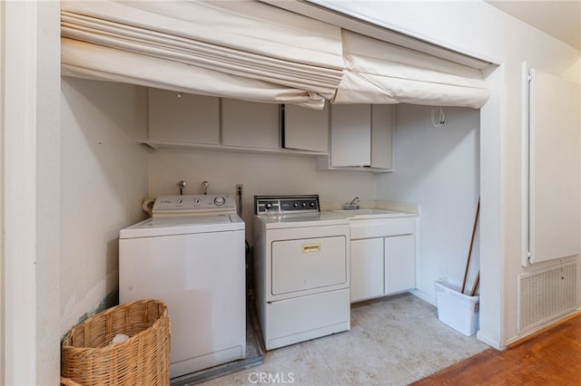 laundry room with cabinets, sink, and washer and dryer