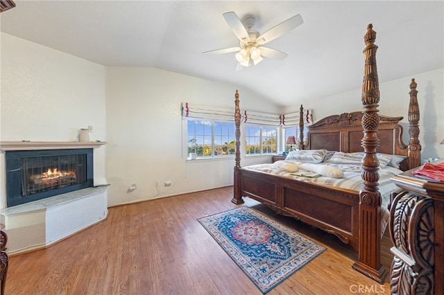 bedroom with ceiling fan, wood-type flooring, and vaulted ceiling