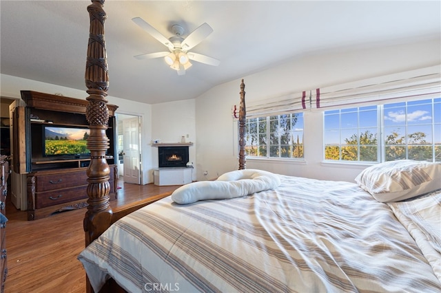 bedroom featuring ceiling fan, wood-type flooring, and vaulted ceiling