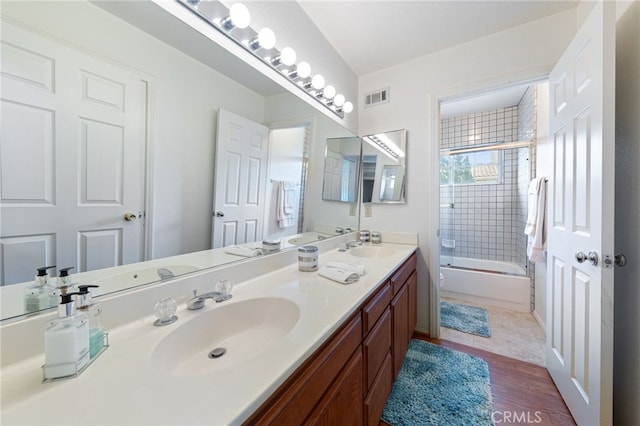 bathroom featuring combined bath / shower with glass door, wood-type flooring, and vanity