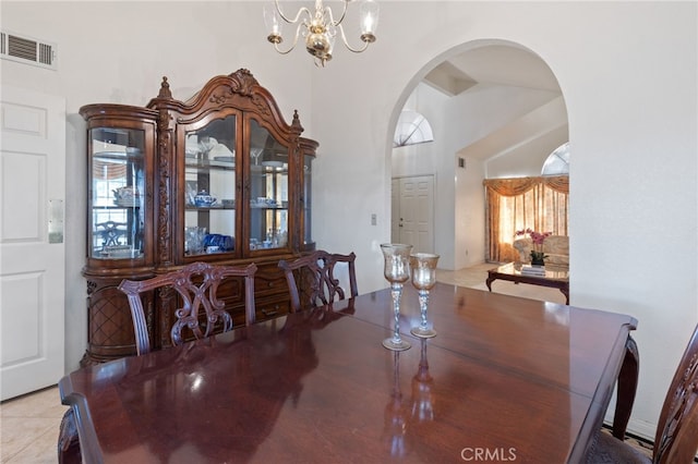 dining area featuring light tile patterned floors, a chandelier, and high vaulted ceiling