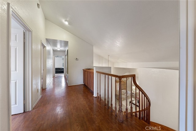 hall featuring dark hardwood / wood-style floors and vaulted ceiling