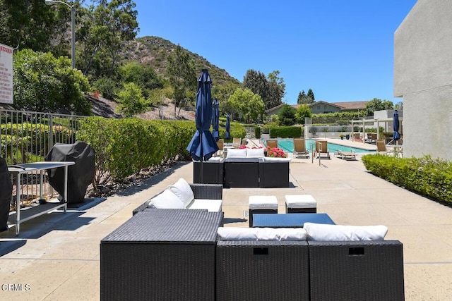 view of patio with a grill, a mountain view, and a community pool