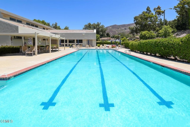 view of swimming pool with a mountain view and a patio