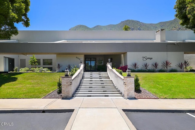 view of front of home with a mountain view and a front yard