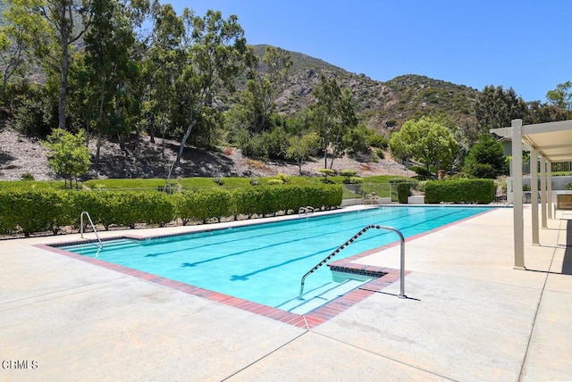 view of pool featuring a mountain view and a patio