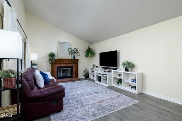 living room featuring dark hardwood / wood-style flooring, high vaulted ceiling, and a brick fireplace