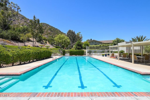 view of pool with a mountain view and a patio