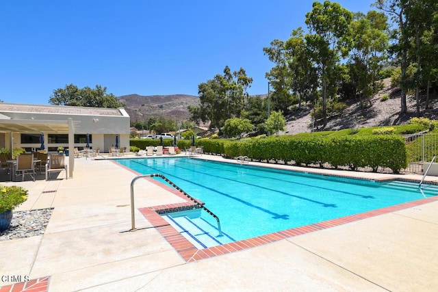 view of pool featuring a mountain view and a patio