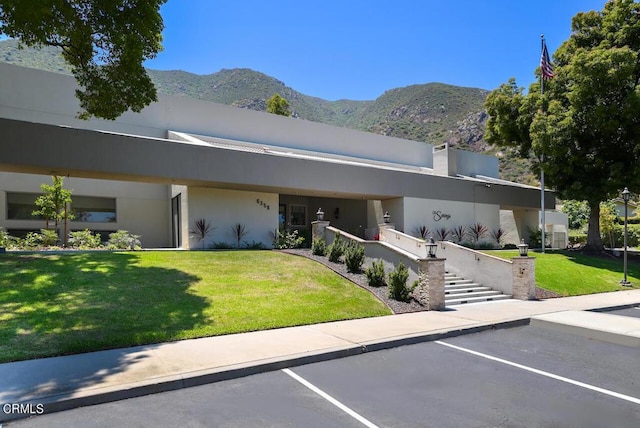 contemporary home with a mountain view and a front lawn